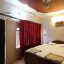 Hotel Ajay International, Agra: simple double room with bed, red curtains, ceiling fan, and air conditioner