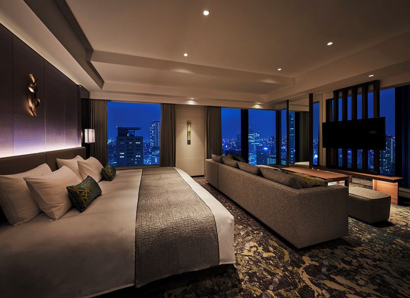The Royal Park Hotel Iconic Osaka Midosuji guest room with city skyline views and sofa seating