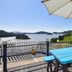 Yeosu Good Morning Pension terrace with blue tables, umbrella and sea view in Yeosu