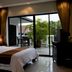 Palm Grove Resort in Pattaya guest room with sliding glass doors to a balcony and palm view