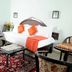 Blooming Paradise, Thekkady: hotel room with bed, side tables, chairs and patterned rug