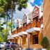 Pousada Campos de Provence in Campos do Jordão with chalet-style balconies and parked cars among tall trees