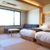 Dantokan Kikunoya in Ōtsu room with two twin beds, large window, and warm wood accent wall