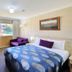 Cootamundra Gardens Motel room with queen bed, purple sofa and window view in Cootamundra