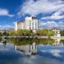 Shangri-La Resort Shangri-La in Diqing reflected in a tranquil lake with blue sky and clouds