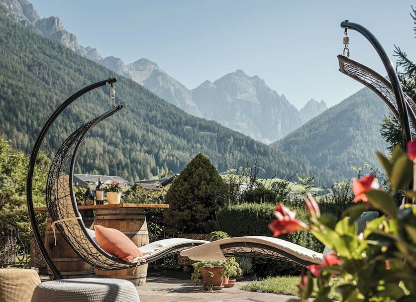 Biohotel Rastbichlhof in Neustift im Stubaital with mountain-view terrace loungers and hanging chairs