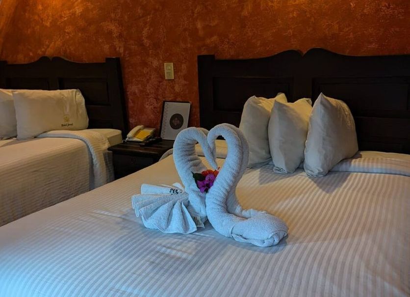 Hotel Jovel guest room in San Cristóbal de las Casas with twin beds and towel swan decor