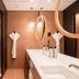 Le Cinq Codet Paris bathroom with double sink vanity, walk-in shower and oval mirrors