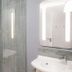 ibis Caen Porte d'Angleterre bathroom with walk-in shower, vanity sink and illuminated mirror in Hérouville-Saint-Clair