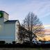 HomeTowne Studios by Red Roof Salem, OR exterior at sunset with sign and bare trees