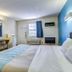 Motel 6 Dickson, TN room with bed, desk, wall-mounted TV, window, and blue accent wall
