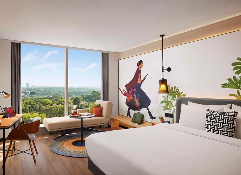 Hyatt Centric Hebbal Bangalore room with city views, desk, seating area and king bed in Bengaluru