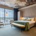 Van der Valk Hotel Brussels Airport room in Machelen with city view, bed, seating area and floral ceiling