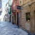 Domatia hotel exterior on a narrow street in Barletta, with stone facade and balcony-lined buildings