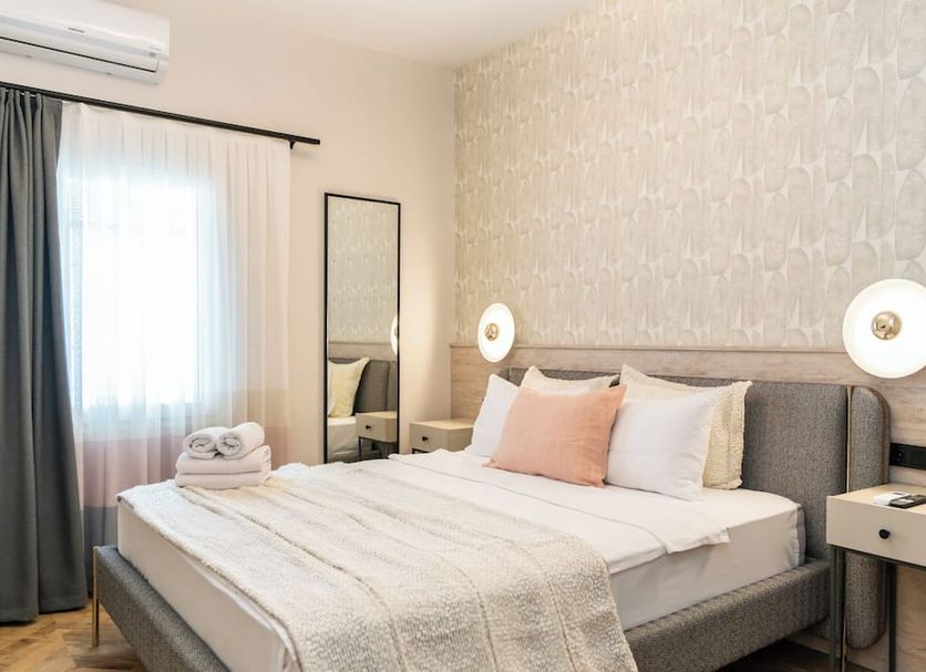 Casa Alloro Bodrum guest room with king bed, bedside tables, floor mirror and sheer curtains