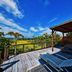 Nagahama Beach Resort Kanon in Nakijin with wooden deck, lounge chairs and ocean-view garden