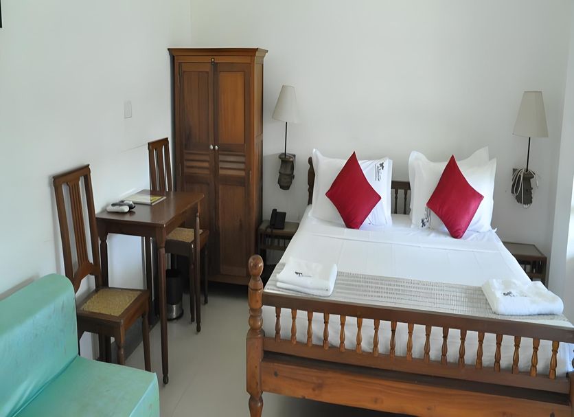Nalla Eco Beach Resort, Pondicherry: simple guest room with wooden bed, desk, chairs and wardrobe