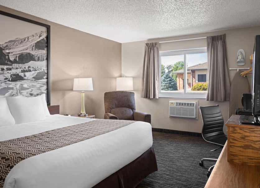 Super 8 by Wyndham Lewistown guest room with king bed, armchair, desk, and window view