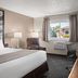 Super 8 by Wyndham Lewistown guest room with king bed, armchair, desk, and window view