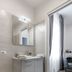Apollo Guest House in Florence bathroom with floating vanity, mirror and doorway to a bright room