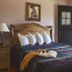 Glacier Park Lodge bedroom in East Glacier Park with wooden bed, open door, and mountain-view balcony
