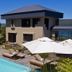 Kanonkop House in Knysna with outdoor pool, sun loungers and umbrellas beside the villa