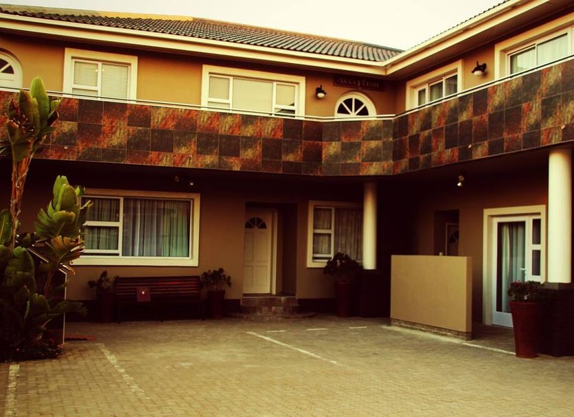 Sea Breeze Guesthouse in Swakopmund courtyard with two-story facade, balcony and potted plants
