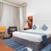 Golden Sands Hotel & Residences in Sharjah room with king bed, blue accents, and floor-to-ceiling curtains