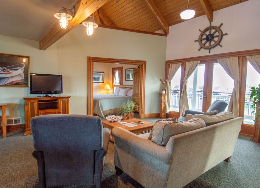 The Swan Hotel in Port Townsend: cozy lounge with sofas, TV, wood ceiling, and marina-view doors