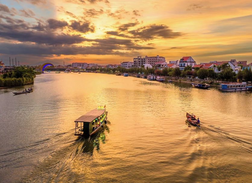 Lantana Riverside Hoi An Hotel river sunset view with boats on the water in Hoi An