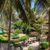 Sarges Hotel in Serrekunda with palm-framed pool, garden, and outdoor seating area