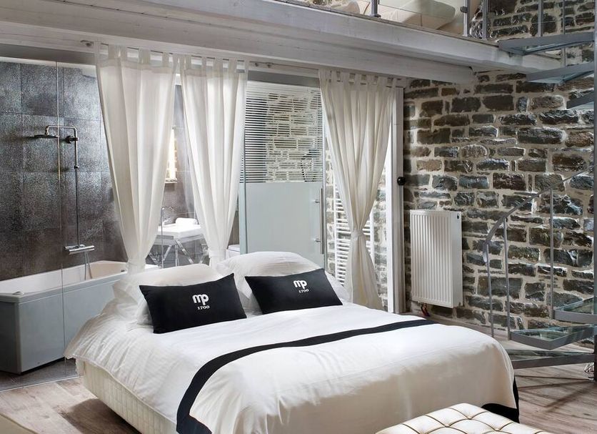 Mikro Papigo 1700 Hotel & Spa room in Aristi with stone walls, king bed, and bathtub
