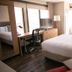 Canal Street, New Orleans hotel room with two beds, desk, TV, and large city-view windows