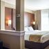 Comfort Suites Minot South guest room with king bed, bedside lamps and window with curtains