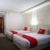 Benakutai Hotel and Apartemen Balikpapan twin guest room with two beds and wall-mounted TV