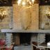 Vettonia in Ávila: rustic lounge with stone fireplace, brick hearth, and chandelier lighting