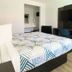 Motel 6 Costa Mesa guest room with two beds, TV, and mirrored vanity area