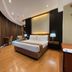 Golden Peak Hotel & Suites powered by Cocotel room in Cebu City with king bed, desk, TV, and warm wood flooring