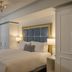 The Adelphi Hotel in Saratoga Springs guest room with king bed, blue tufted headboard and wardrobe