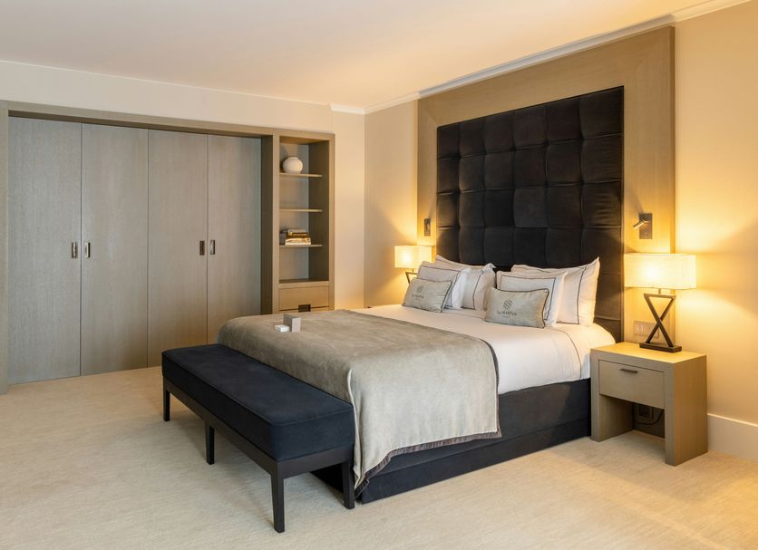 La Réserve Resort in Knokke Heist guest room with king bed, bench, and built-in wardrobe