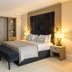 La Réserve Resort in Knokke Heist guest room with king bed, bench, and built-in wardrobe