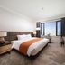 Jeju Sun Hotel & Casino in Jeju City guest room with king bed and large city-view window