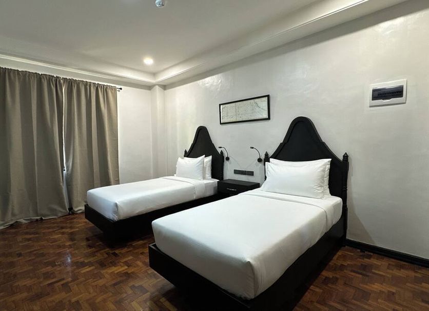 La Planta Hotel And Restaurant in Bais City: twin beds in a guest room with curtains and wood floor
