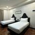 La Planta Hotel And Restaurant in Bais City: twin beds in a guest room with curtains and wood floor