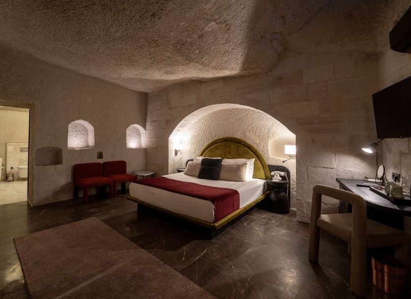 Artemis Cave Suites in Göreme, cave-style guest room with arched alcove bed and seating area