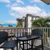 Balcony with table and chairs at Harbour House At The Inn in Fort Myers Beach, overlooking palm trees
