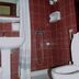 Gythion Hotel in Gytheio bathroom with red tile walls, shower, sink, and toilet