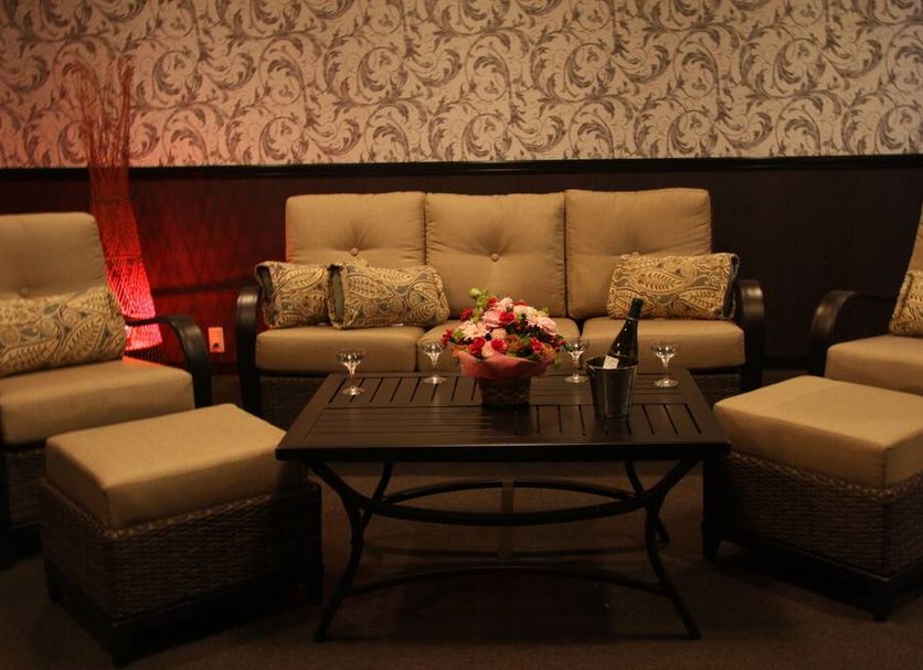 the b hachioji lounge seating area with beige sofas, armchairs, and a coffee table in Hachiōji
