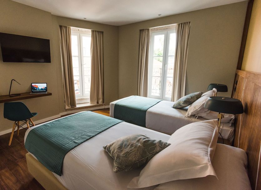 Rossio Boutique Hotel Lisbon room with two twin beds, wall-mounted TV and tall windows