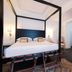 Hotel Michelangelo & Day Spa room in Montecatini Terme with four-poster bed and colorful rug